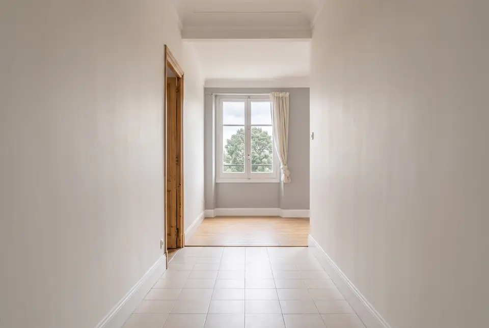 La misma pared después de pintar, con acabado liso en blanco y molduras esmaltadas
