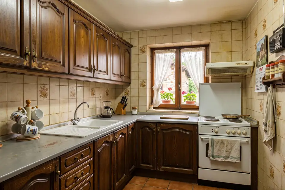 Cocina en Asturias antes del lacado, con los muebles de madera oscura y azulejo antiguo
