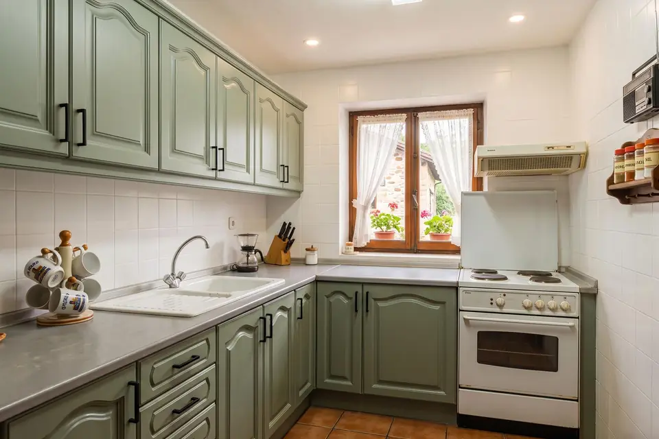 La misma cocina con los muebles lacados en verde y el azulejo pintado en blanco