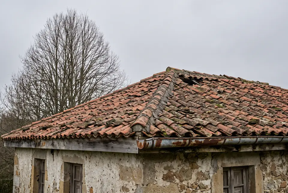 Tejado en Asturias antes de la reforma, con tejas rotas, musgo y limahoyas deterioradas